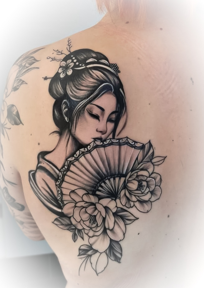 Tätowierung auf dem Rücken: Frau mit Fächer, Blumen und elegantem Haarknoten in Schwarz und Grau.